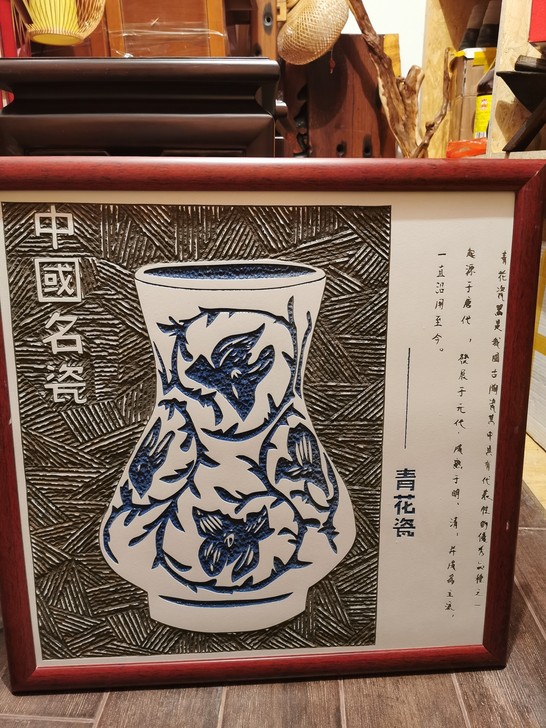 此为中国独有的瓷板雕刻画，雕刻一个青花瓷罐...